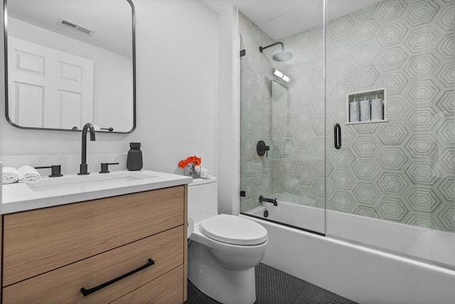 full bathroom featuring vanity, shower / bath combination with glass door, and toilet