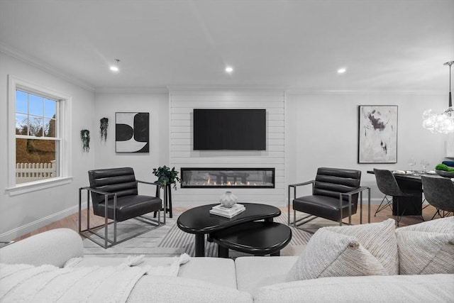 living room with crown molding, a large fireplace, and light hardwood / wood-style floors