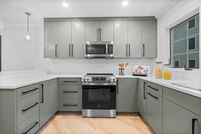 kitchen featuring stainless steel appliances, gray cabinets, pendant lighting, and backsplash