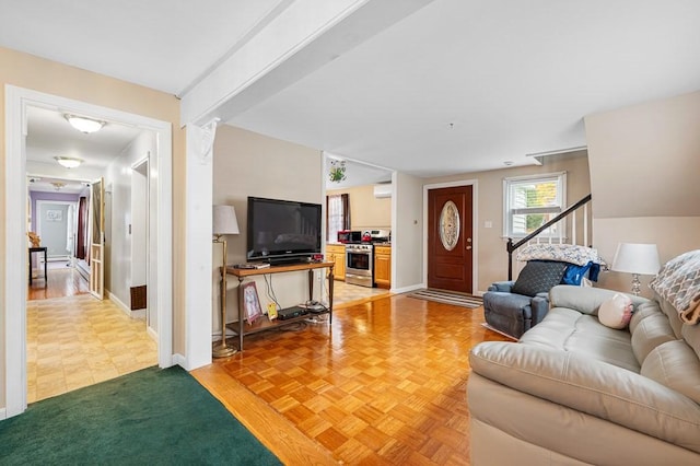 living room with baseboards and a wall mounted air conditioner