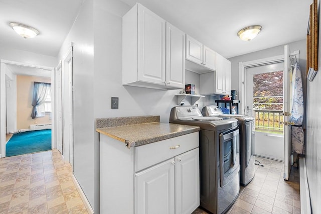 laundry area featuring cabinet space, a baseboard heating unit, and separate washer and dryer