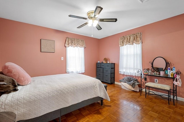 bedroom featuring multiple windows, a ceiling fan, and baseboards