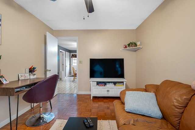 living area featuring ceiling fan and baseboards