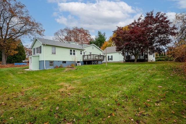 rear view of house with a yard and a wooden deck