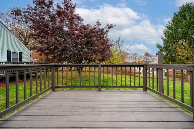 wooden deck featuring a lawn