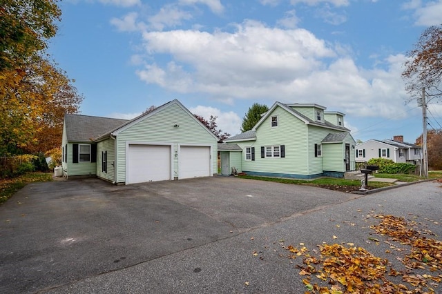 view of front of property with an attached garage, a shingled roof, and aphalt driveway