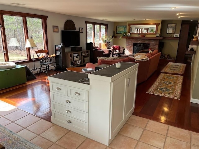 150 Sagamore St, Hamilton, MA 01982 - living room with baseboard heating, a brick fireplace, and light tile patterned floors