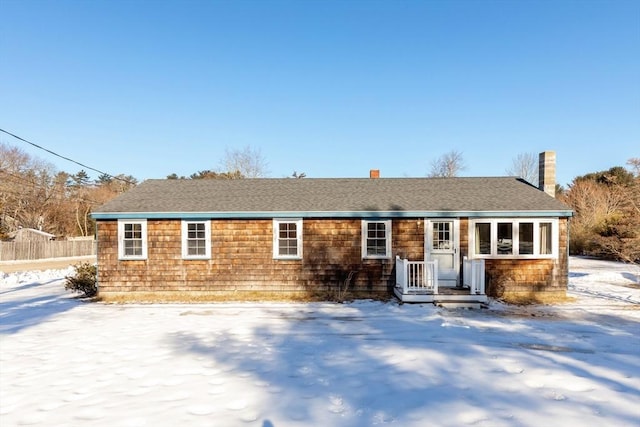 single story home with a shingled roof and fence