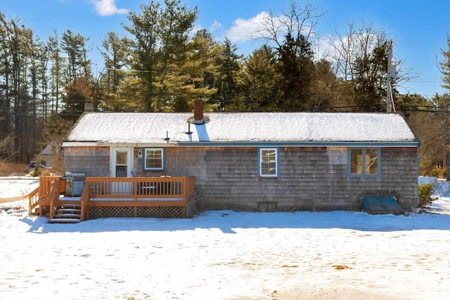 snow covered house featuring a deck