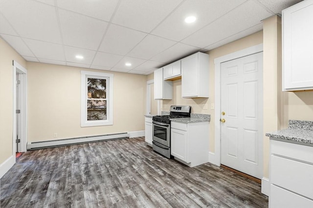 kitchen featuring a paneled ceiling, white cabinets, a baseboard radiator, and stainless steel gas range