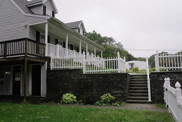 view of property exterior with covered porch and roof with shingles