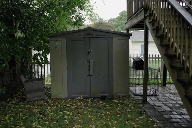 view of shed featuring fence and stairway