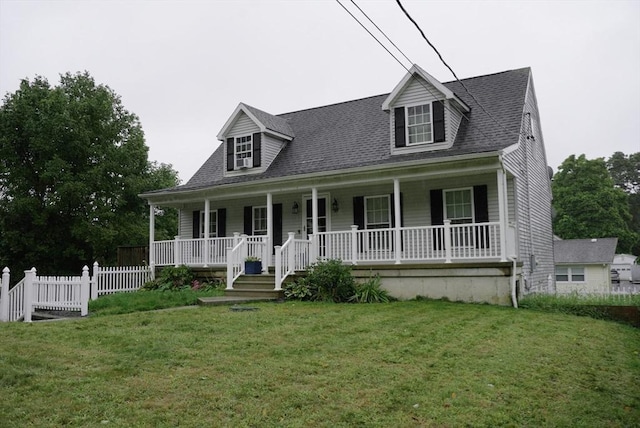 cape cod-style house with covered porch, a shingled roof, and a front yard