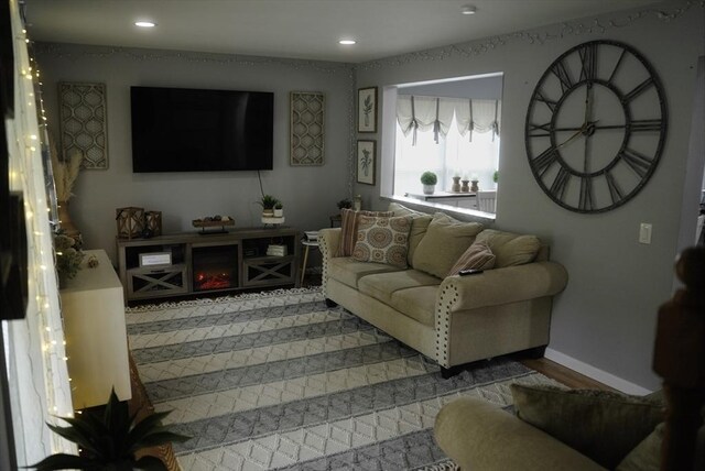 living room with recessed lighting, light wood-type flooring, and baseboards