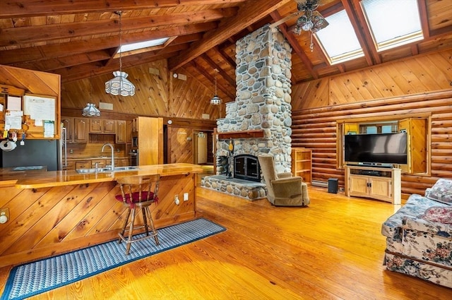 7 Hawthorne Dr, Southampton, MA 01073 - kitchen with a skylight, high vaulted ceiling, beam ceiling, light wood-style flooring, and a fireplace