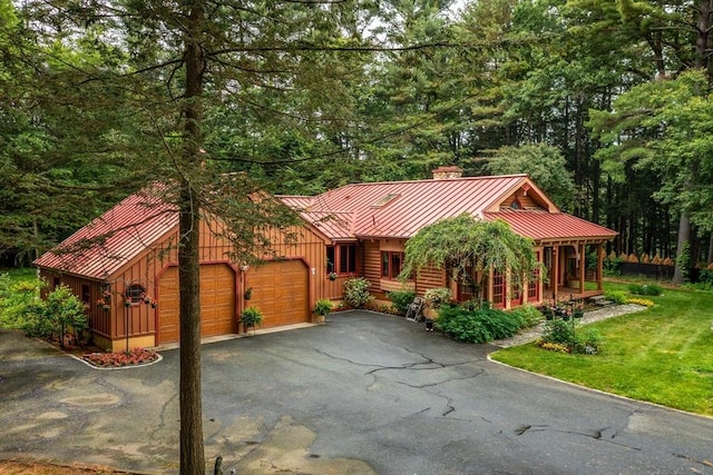 7 Hawthorne Dr, Southampton, MA 01073 - chalet / cabin featuring a standing seam roof, a chimney, an attached garage, a metal roof, and driveway