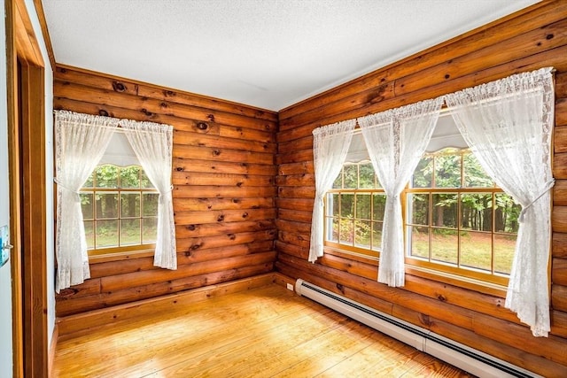 7 Hawthorne Dr, Southampton, MA 01073 - unfurnished room with a baseboard heating unit, plenty of natural light, light wood-type flooring, rustic walls, and a textured ceiling