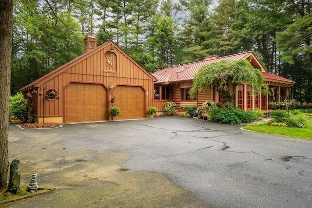 7 Hawthorne Dr, Southampton, MA 01073 - view of front of property featuring a chimney, a standing seam roof, board and batten siding, a metal roof, and an attached garage
