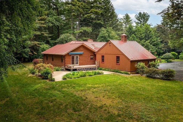 7 Hawthorne Dr, Southampton, MA 01073 - rear view of house featuring a chimney, a standing seam roof, a metal roof, a lawn, and a wooden deck