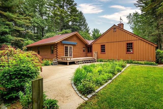 7 Hawthorne Dr, Southampton, MA 01073 - rear view of house with a metal roof, log exterior, a yard, and a chimney