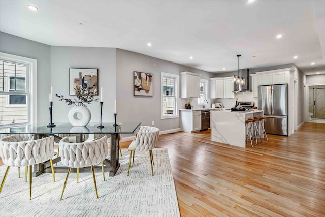 dining space with light hardwood / wood-style flooring and sink