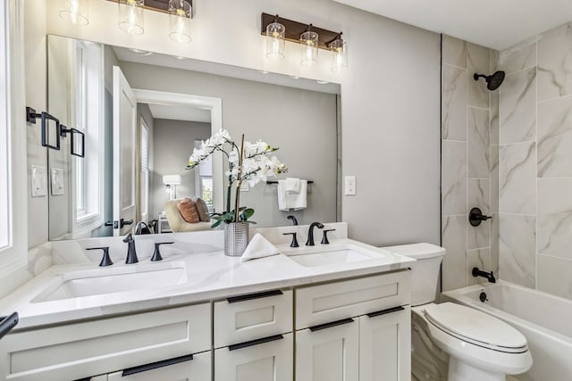 full bathroom featuring tiled shower / bath combo, vanity, and toilet