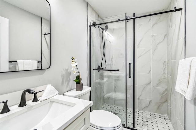 bathroom with a shower with shower door, vanity, and toilet