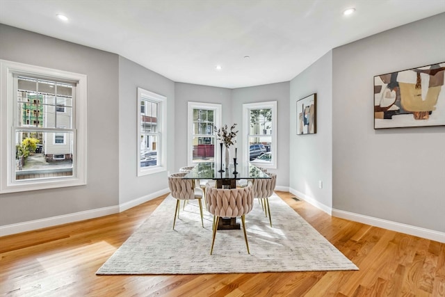 dining area with light hardwood / wood-style flooring and a healthy amount of sunlight