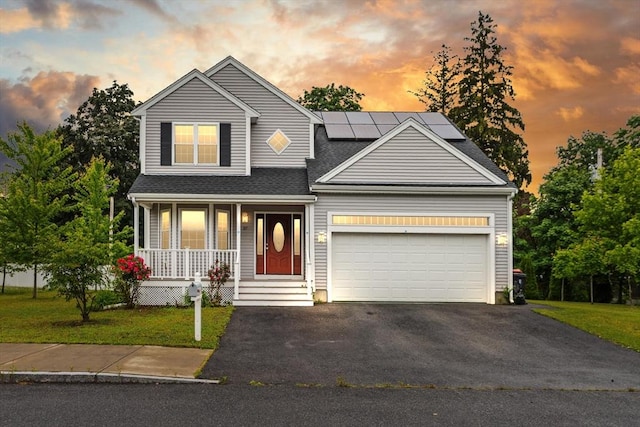 37 Leach Ave, Brockton, MA 02301 - traditional home featuring covered porch, asphalt driveway, an attached garage, roof mounted solar panels, and a yard