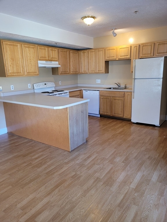 kitchen with kitchen peninsula, a textured ceiling, white appliances, sink, and light hardwood / wood-style flooring