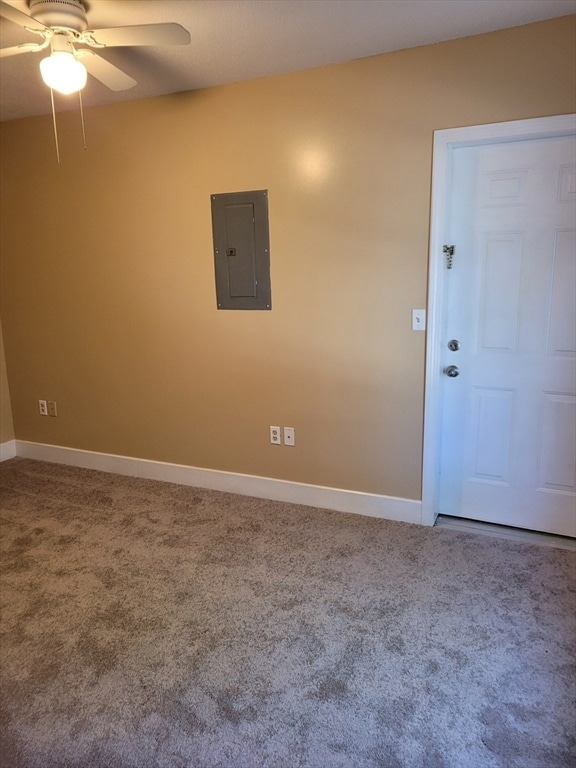 spare room featuring carpet flooring, electric panel, and ceiling fan