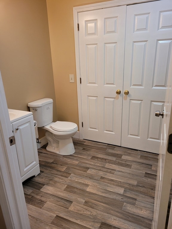 bathroom featuring vanity, wood-type flooring, and toilet