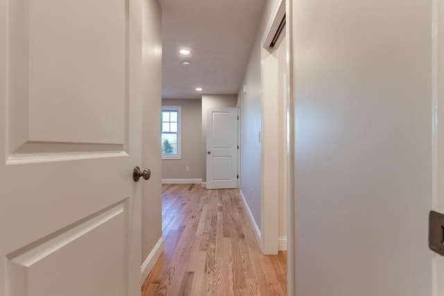 hallway with light hardwood / wood-style floors