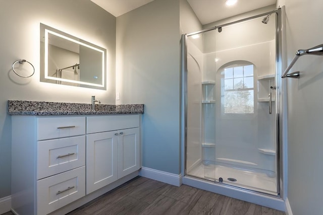 bathroom featuring hardwood / wood-style floors, vanity, and a shower with shower door