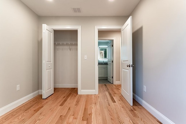 unfurnished bedroom featuring a closet and light hardwood / wood-style floors