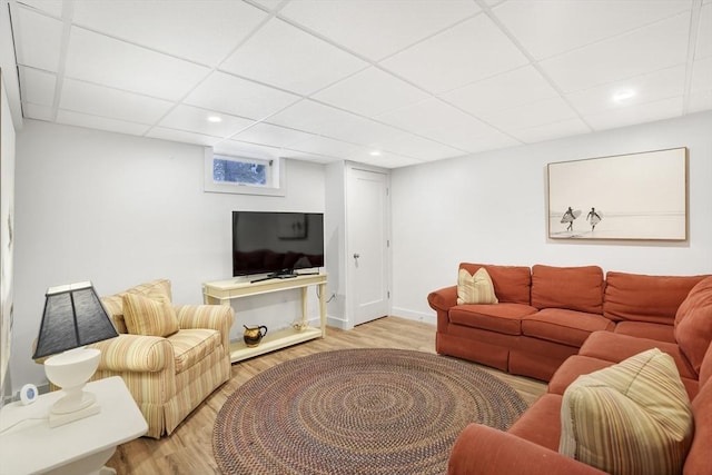 living room with a drop ceiling and light hardwood / wood-style floors