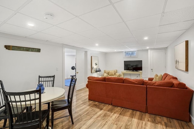 living room featuring a drop ceiling and light wood-type flooring