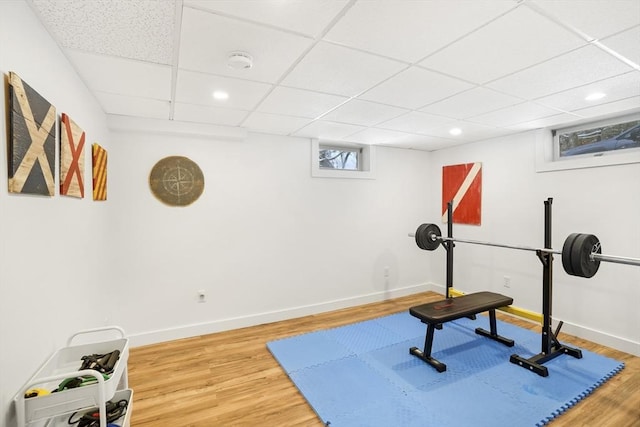 exercise room featuring a paneled ceiling and wood-type flooring