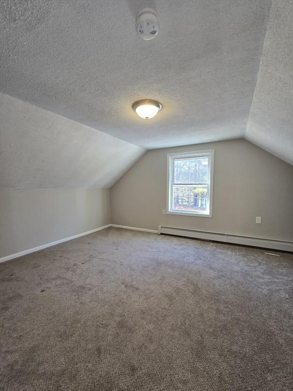 bonus room featuring carpet flooring, vaulted ceiling, a textured ceiling, and baseboard heating