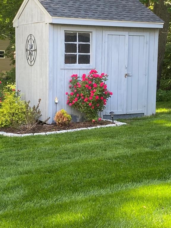 view of outbuilding with a yard