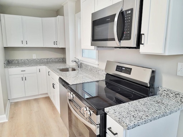 kitchen with appliances with stainless steel finishes, sink, and white cabinets