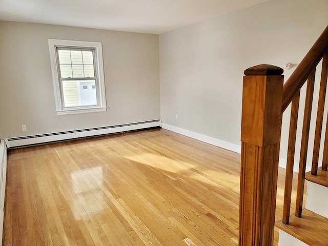 empty room with a baseboard radiator and light wood-type flooring