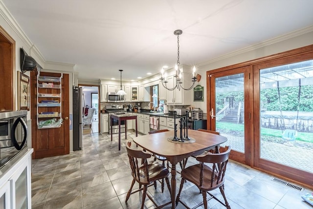 dining space with a chandelier, visible vents, and ornamental molding