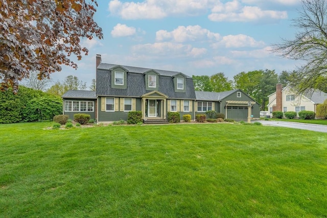 dutch colonial with a garage, a chimney, aphalt driveway, a front lawn, and roof with shingles