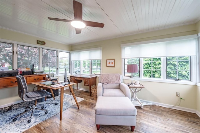home office featuring a ceiling fan, baseboards, ornamental molding, and wood finished floors