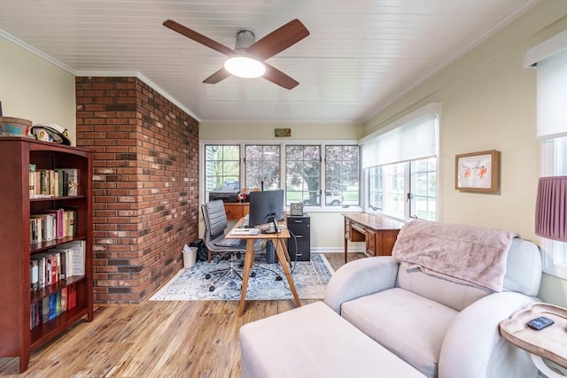 office space featuring ceiling fan, ornamental molding, brick wall, and light wood-type flooring
