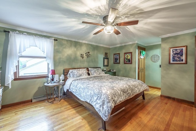 bedroom featuring a baseboard heating unit, baseboards, ceiling fan, crown molding, and hardwood / wood-style floors