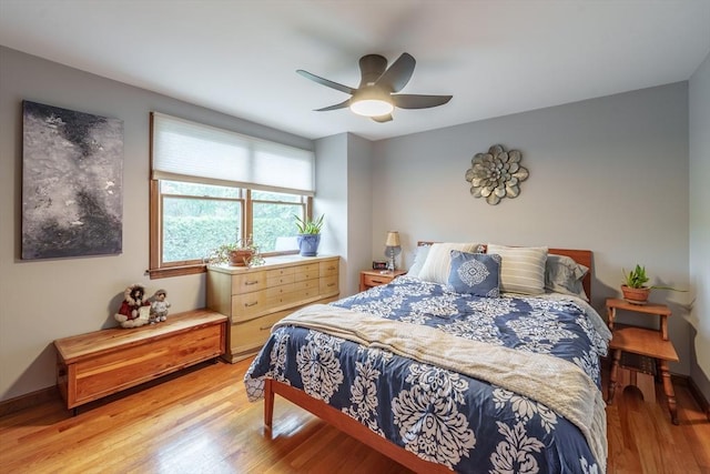 bedroom featuring a ceiling fan, baseboards, and light wood-style flooring