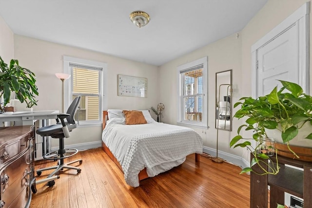 bedroom with baseboards and hardwood / wood-style flooring