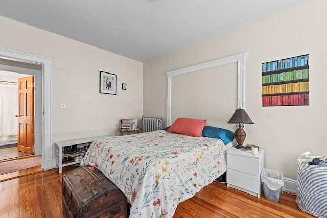 bedroom with radiator and wood finished floors